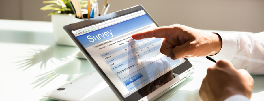 Photo of a person using a touchscreen tablet device to answer an online survey.