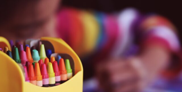 child drawing with crayons
